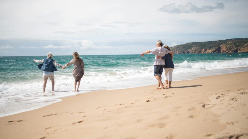 Retired couple walking on a beach enjoying their retirement in the UK