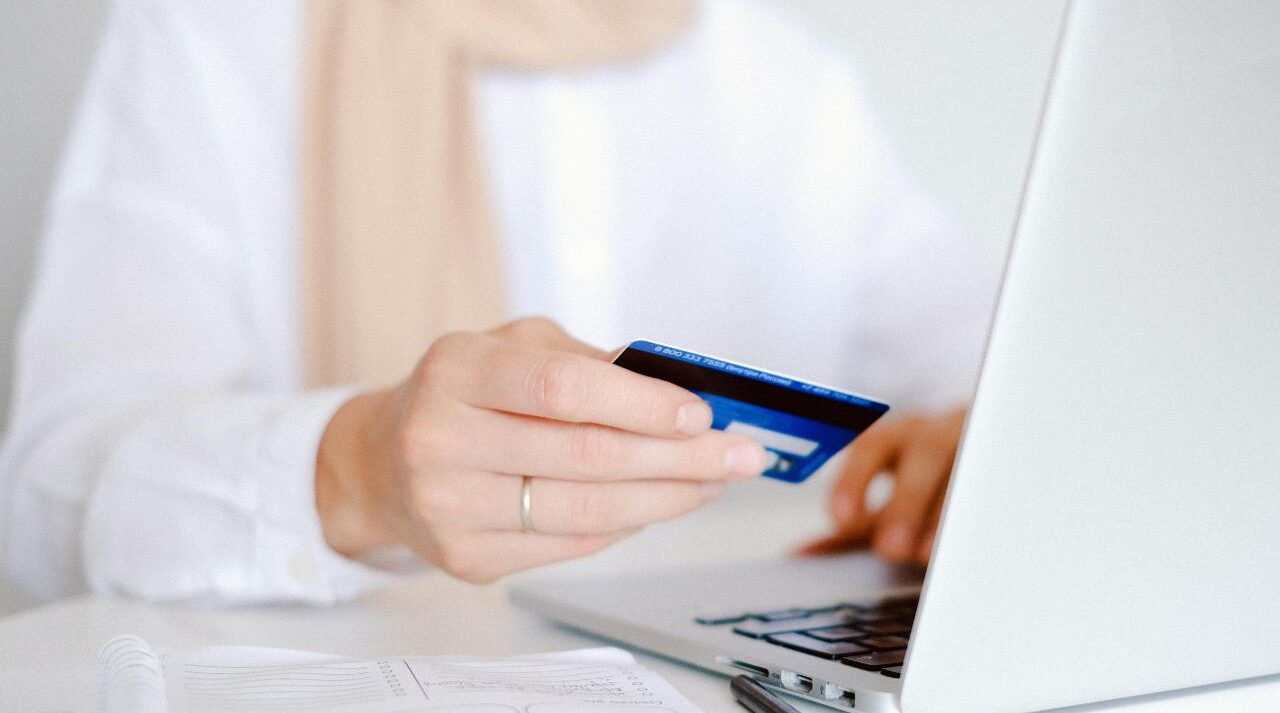 Person using laptop to fix bad credit score UK with Experian and credit report on screen