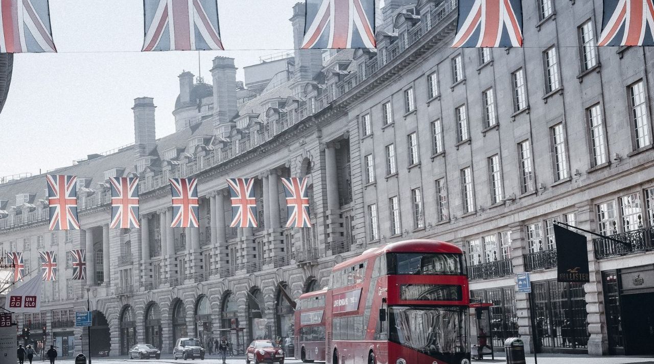 London street with Union Jack flags and a red bus, illustrating the UK cash ISA limit change in 2027