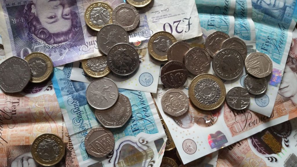 Pound coins and banknotes showing the cash income from dividend growth investing